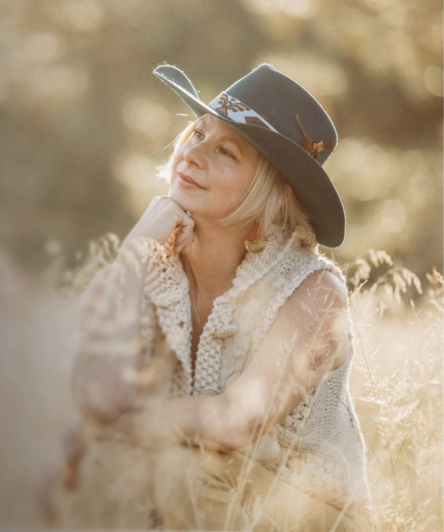 Emilee Garfield wearing a hat and cream sweater outdoors in sunlight.